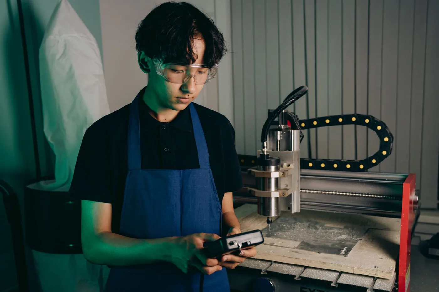 An engineer in safety glasses operating advanced machinery